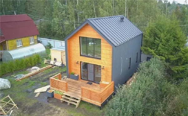 Фото готового дома в стиле barnhouse на фоне леса