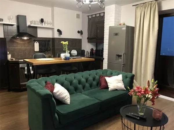 Зеленый диван на кухне как элемент зонирования