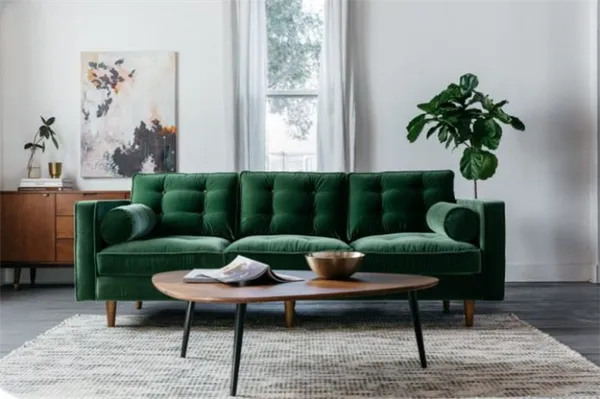 Зеленый диван на фоне белой стены