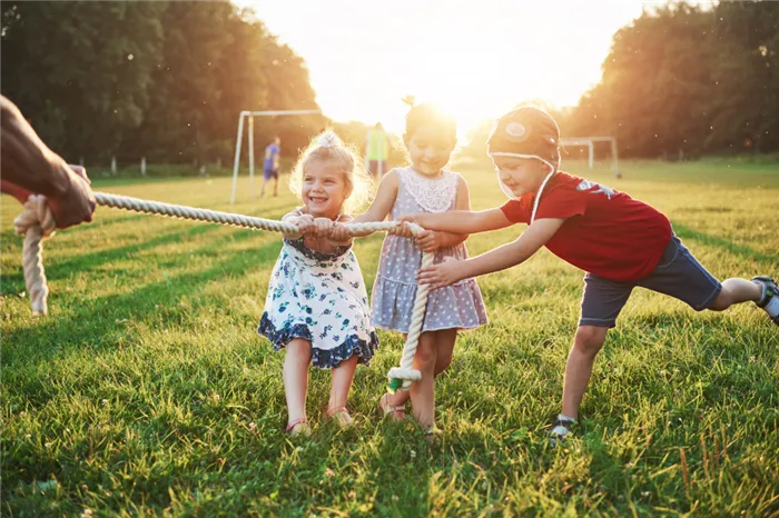 children-play-with-dad-in-the-park-they-pull-the-rope-and-have-fun-laying-on-a-sunny-day.jpg